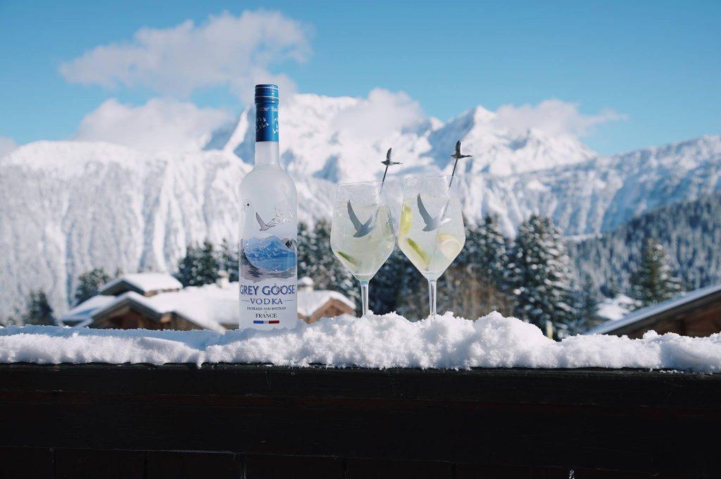 grey goose vodka, üveg és poharak, hegyes táj a háttérben