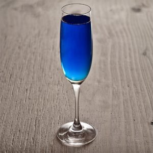 Diamond Blue koktél, pezsgős pohárban, világos fa asztalon