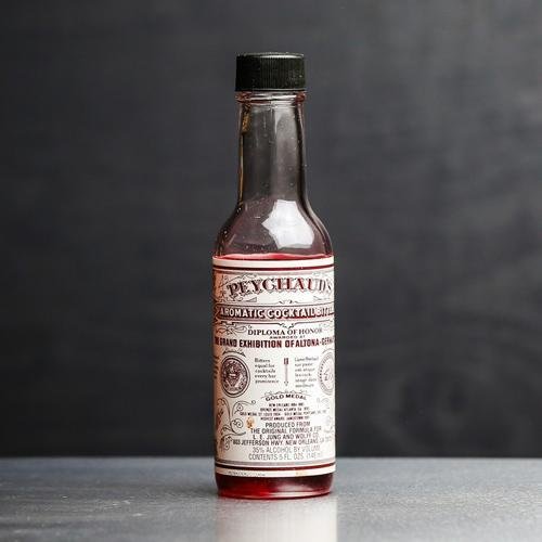 Peychaud's Bitters üveg, szürke háttérrel