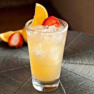 Boston rum punch, pohárban, eperrel és naranccsal díszítve 