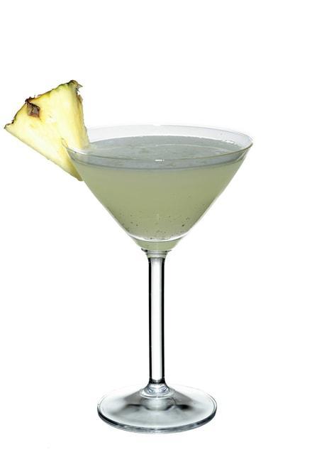 Pineapple and cardamom martini koktél, pohárban, fehér háttérrel